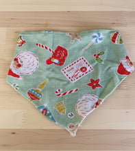 Load image into Gallery viewer, Fabric with Christmas-themed designs on a green surface