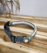 Load image into Gallery viewer, A cord-wrapped dog collar with a green strap and metal ring, shown hanging against a wooden wall.