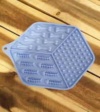 Load image into Gallery viewer, Blue Lick Mat with bone and fish shapes on a wooden surface