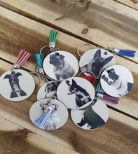 Load image into Gallery viewer, Keychains with dog images and colorful tassels on a wooden surface