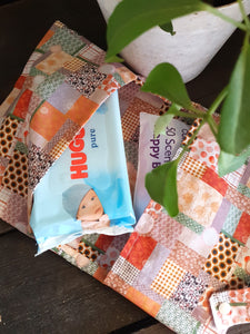 Nappy wallet in use with wipes and nappy on a wood background