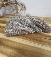 Load image into Gallery viewer, Knitted gray scarf draped over a wooden surface with a blurred natural background
