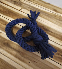Load image into Gallery viewer, A dark blue braided rope dog toy with tassel ends, laid flat on a light-colored wooden plank surface.
