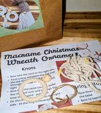 Load image into Gallery viewer, Macrame Christmas wreath ornament kit with instructions and materials on a wooden surface
