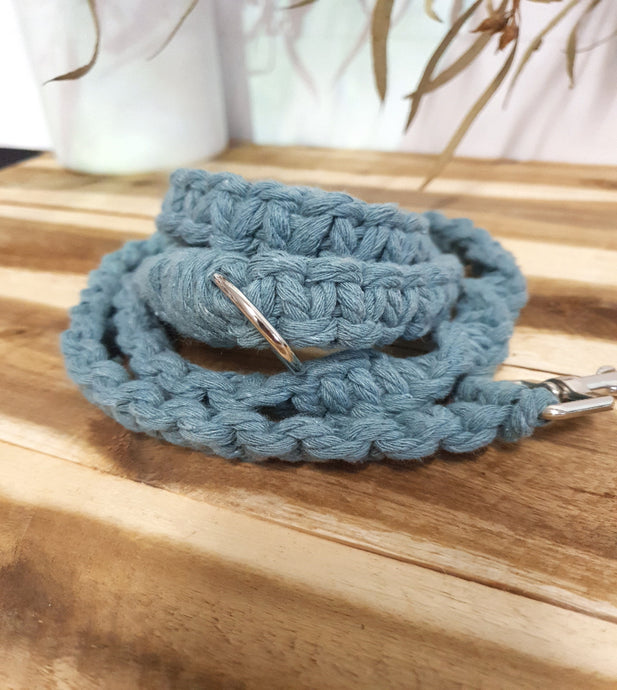 Blue braided leash with metal clip on a wooden surface