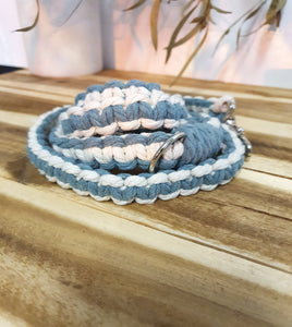 Blue and white braided lead with a metal buckle on a wooden surface