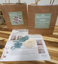 Load image into Gallery viewer, Brown packaging with a keychain kit and instructions on a wooden surface
