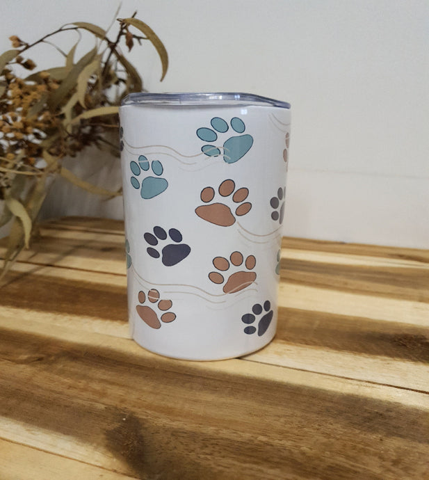 Tumbler with paw print design on a wooden surface