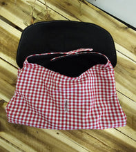 Load image into Gallery viewer, A handmade Dog coat with a red and white gingham checkered fabric exterior and a solid black fabric interior, displayed on a light-colored wooden plank surface.
