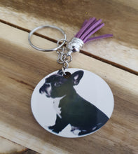 Load image into Gallery viewer, Keychain with a circular tag featuring a French Bull Dog design on a wooden surface
