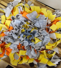 Load image into Gallery viewer, A pile of colorful dog chew toys made from cut fabric, featuring yellow, light blue-gray, and orange pieces, arranged on a wooden slatted surface.

